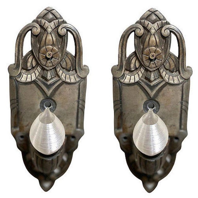 Pair of early art deco machined aluminum wall sconces with graceful curves and geometric lines with a floral motifs in the...