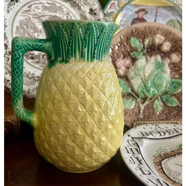 Charming antique majolica pineapple pitcher with pink interior.A delightful antique majolica pitcher modeled as a...