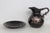 This charming Pitcher and Underplate 2pc Set is made of ceramic. This gorgeous set features a bold black base color with...