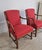 A pair of rare Swedish Grace armchairs in stained beech and red linen/cotton fabric. Paw shaped legs and rounded armrests....