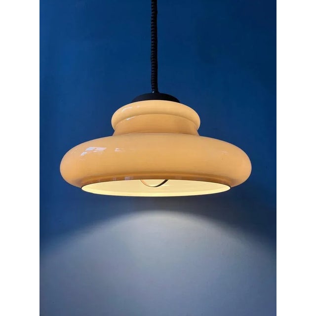A space age pendant lamp by Herda with a beige, acrylic glass mushroom shade. The height of the lamp can be adjusted with...
