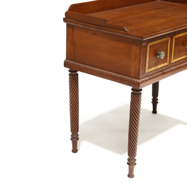 An elegant American Classical work table dating to the early 19th century, crafted circa 1820–1830 and raised on finely...