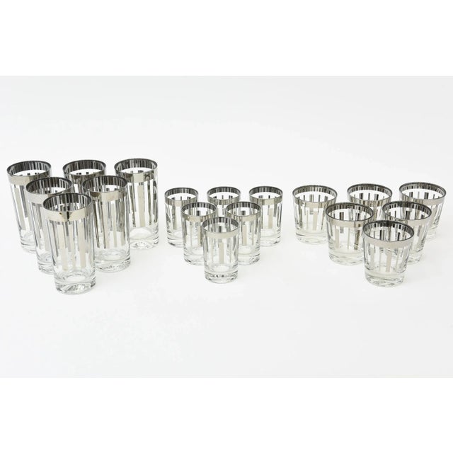 This fabulous set of vintage 1950's glass barware has geometric lines of silver and a silver rim against clear glass....