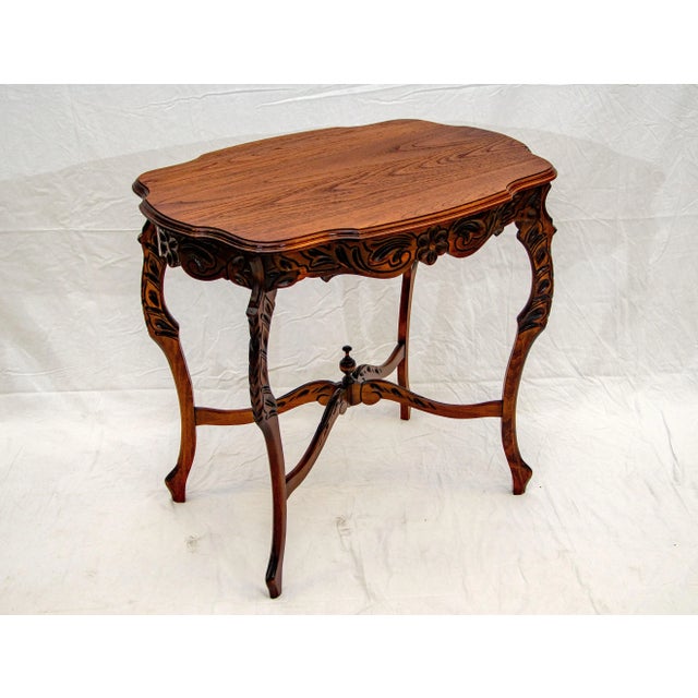 Nice occasional table with a shaped top and an ogee edge. The entire frame under the tabletop is carved and there is a...