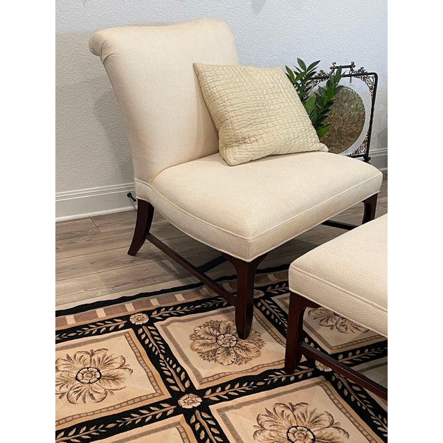 This classic chair and ottoman was made by Barbara Barry for Baker furniture. The wood is mahogany. There is minimal wear....