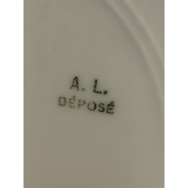 Scalloped edge hand-painted French porcelain plates, serving platter, and gravy boat with saucer. Tresseman & Vogt in...