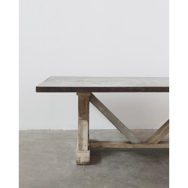 Zinc-top trestle table with a heart pine wood base, dated by the owner to approximately 1990–2000. The distressed zinc top...