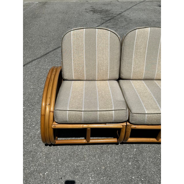 A restored, 1950s rattan 3-seater sofa that has been recently refinished and reupholstered in the fabric and welting...