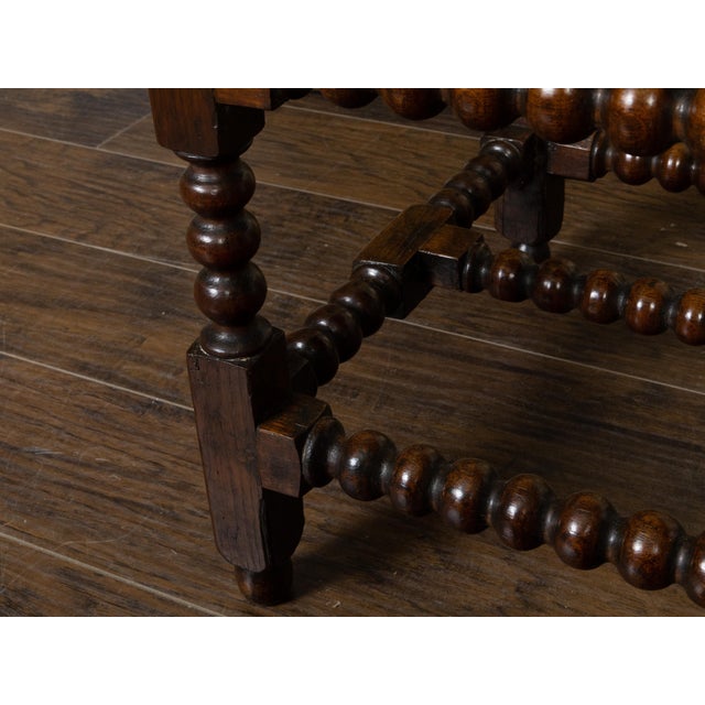An English oak table from the 19th century, with bobbin legs, single drawer. H-Form stretcher and Chippendale style brass...