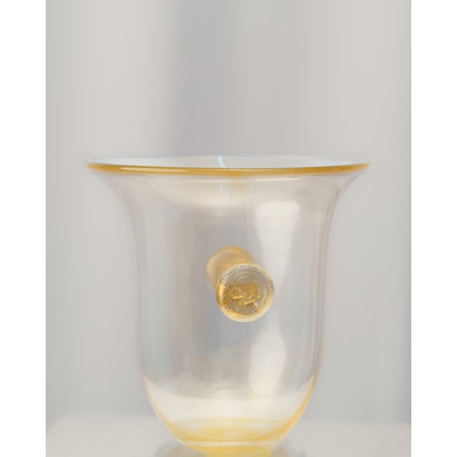 Decorative vase with a wide, goblet-shaped mouth, made using the traditional glassblowing technique. The translucent glass...