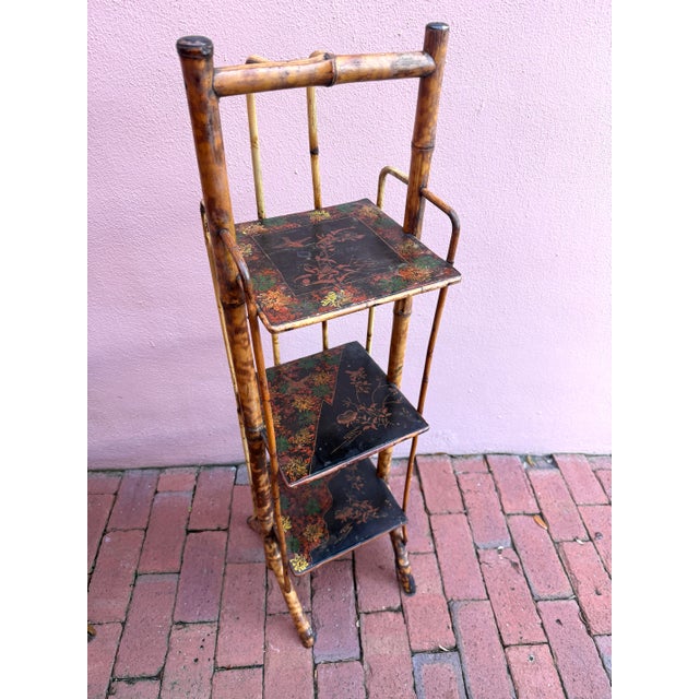 Antique Burnt tortoise rattan etagere. Three Black lacquered Japonisme shelves. Great scale for a powder room. Brass caps...