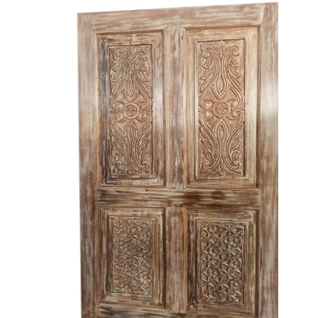 This vintage carved wood door features a beautifully distressed beige patina that exudes rustic farmhouse charm....
