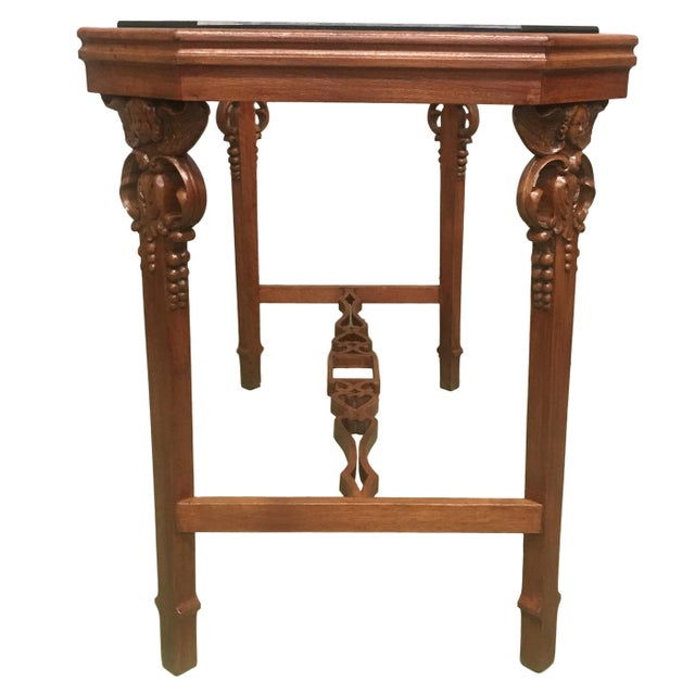 Turn of the century English Arts & Crafts four legs table with a canted corner top with carved cherubs in the four legs.
