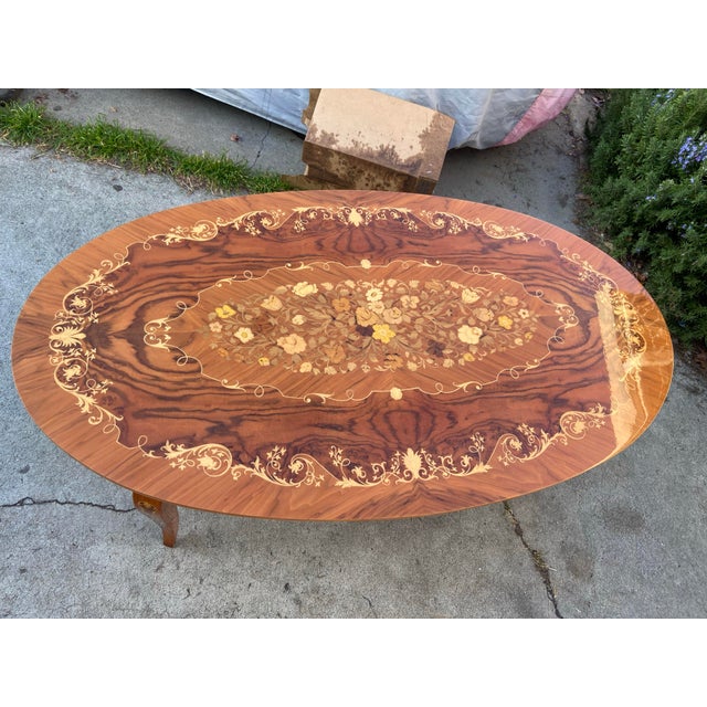 The Vintage Mid Century Modern Italian Inlaid Oval Coffee Table is a stylish and unique piece of furniture perfect for any...