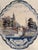 Antique hand painted Delft wall plaque with scalloped blue edge depicting a Dutch canal scene. Circa late 19th or early...