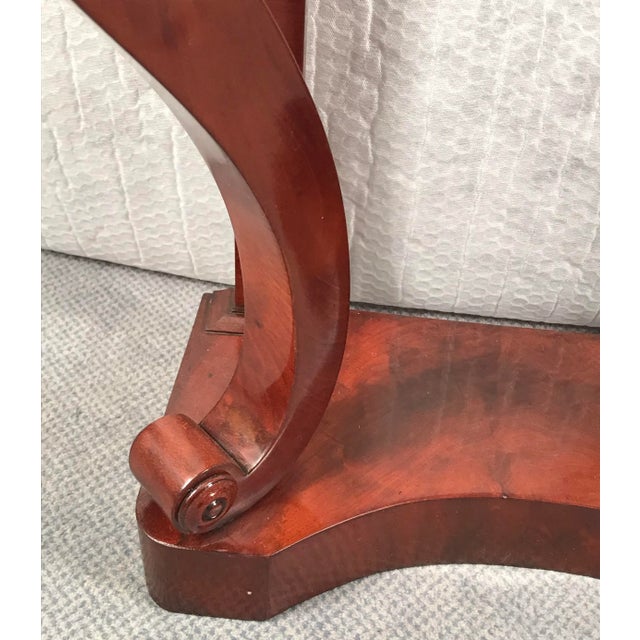 The curved legs of this unique small Biedermeier mahogany console table stand on a rectangular concave base. Exquisite...