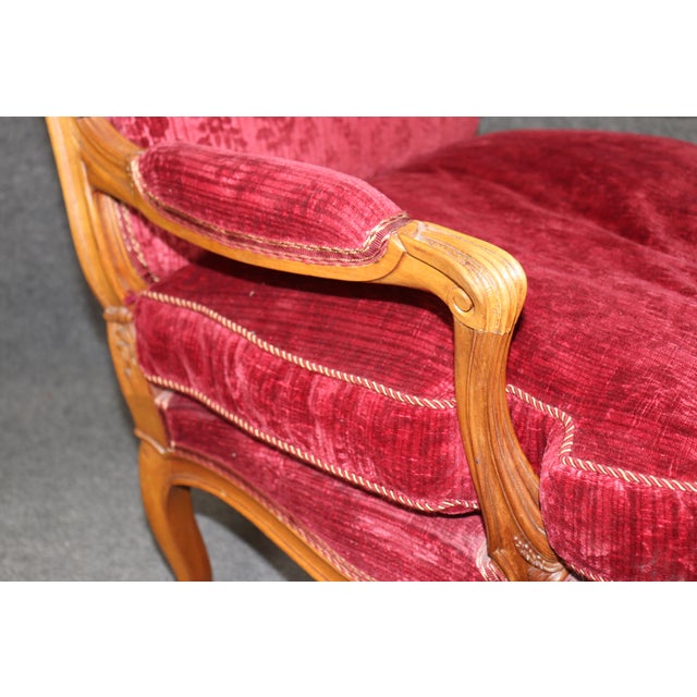 A striking and exceptionally decorative pair of French Louis XV style fauteuil armchairs, richly carved in solid beechwood...