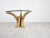 Elegant center table featuring faux elephant tusks made from resin mounted on a metal base with a round beveled glass top....