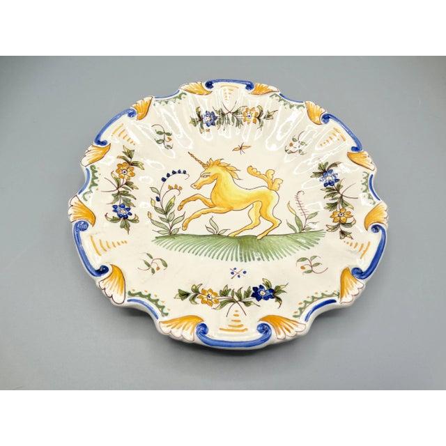 Early 20th-Century French Moustiers plate with unicorn. This lovely lobed faience plate is hand painted with a yellow and...