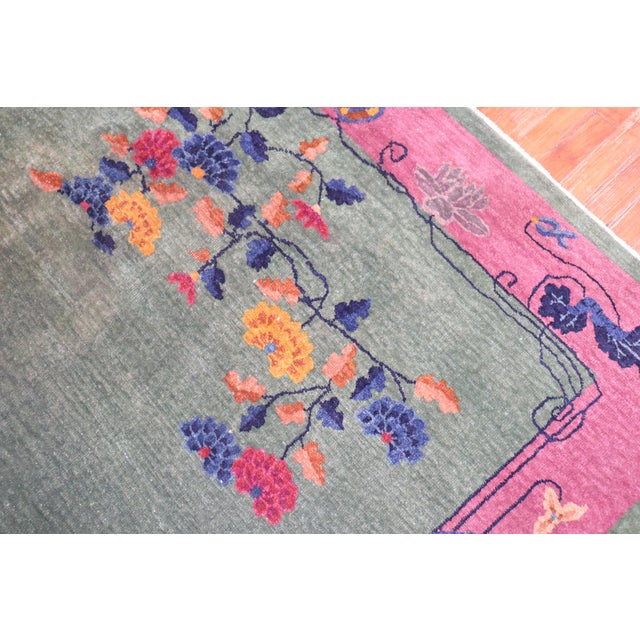 Enchanting early 20th century Chinese Art Deco carpet with a spacious floral design in dominant accents in green and pink....
