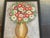 That’s a lovely still-life painting — the artist’s use of warm golds and vivid reds gives the bouquet a cheerful, almost...