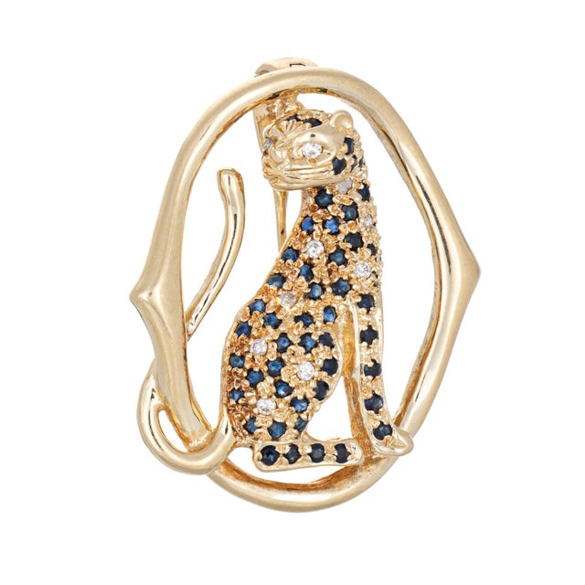 Finely detailed diamond & sapphire panther pendant crafted in 14 karat yellow gold (circa 1970s). Diamonds total an...