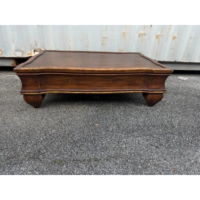 This is quite an unusual style coffee table. It made of Pitch Pine and has gold gilt along the edges. The legs are bulbous...