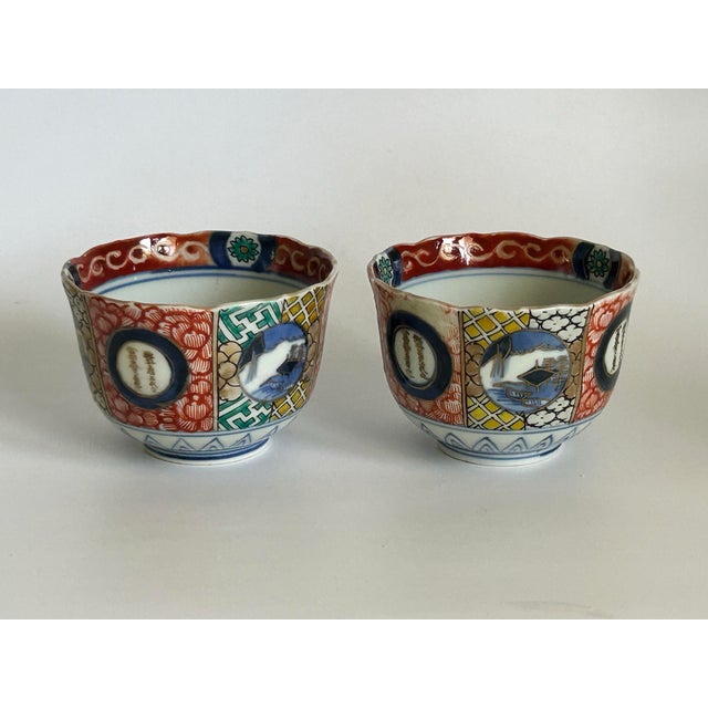 A pair of antique Japanese Imari porcelain tea bowls dating to the Meiji period (1868–1912). The decoration features...