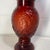 This is a vintage 1970s ruby red glass apothecary jar produced by the Wheaton Glass Company. It features an embossed...