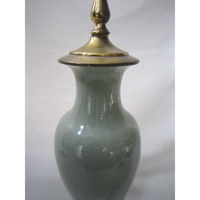 Beautiful Asian porcelain Celadon lamp. Subtle design under the glaze with footed wood bottom. The wiring is in good...