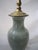Beautiful Asian porcelain Celadon lamp. Subtle design under the glaze with footed wood bottom. The wiring is in good...