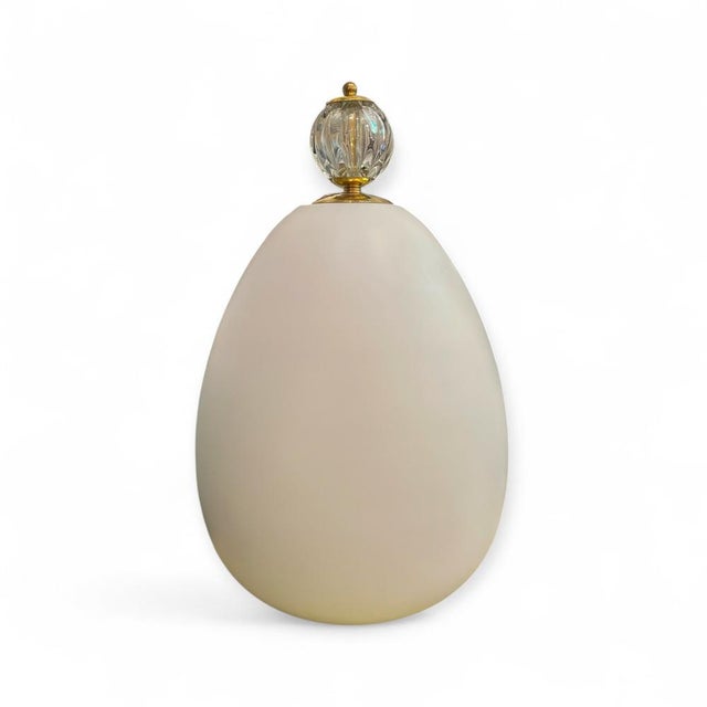 Egg-shaped table lamp made of Murano glass. Crafted using the blown glass technique in a white tone, it provides a soft,...