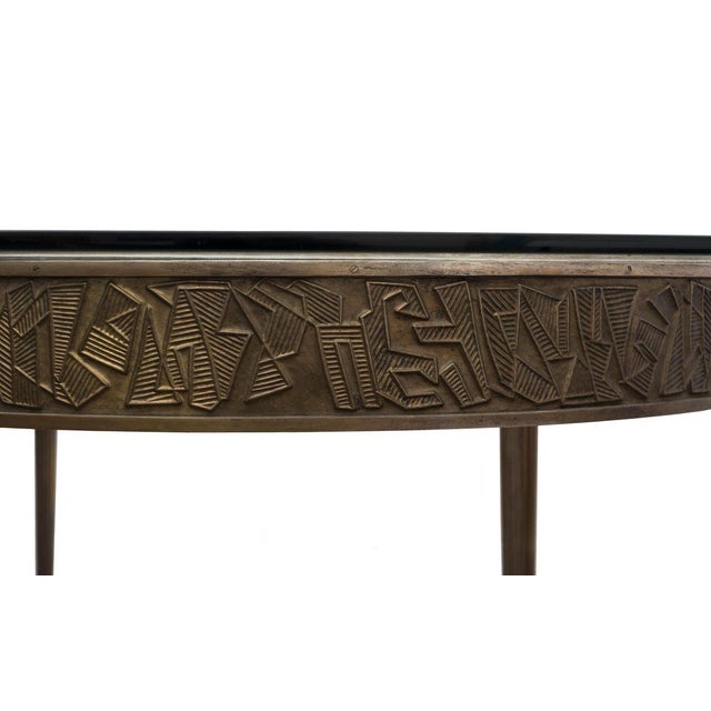 Glass shelf and golden metal legs with embossed border finely decorated with geometric motifs. Certificate of authenticity...