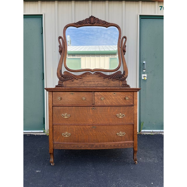 An early American crafted tiger oak dresser from the late 1800-early 1900 era. Brass drawer pulls and keyhole covers elude...