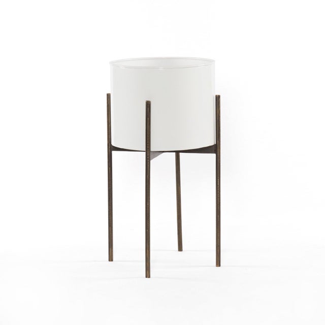 Slim legs of weathered brass-finished iron support an inset planter of glossy white iron. Plastic plant liner recommended...