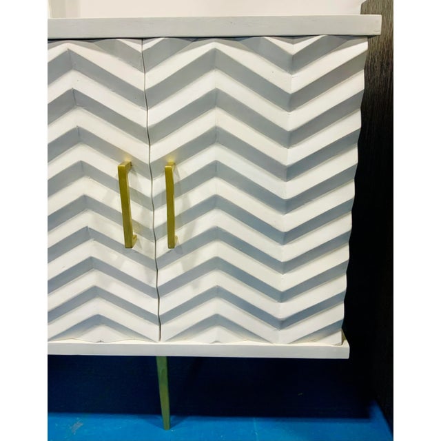 Stylish Modern White Carved Wood Herringbone Credenza, distressed finished, brass finished feet and pulls, four doors, two...
