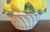 This is a classic Italian lemon topiary in a white basketweave basket. Bright and cheery decor for a kitchen or sunroom.