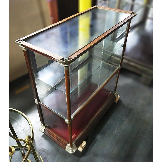Antique early 20th century, shallow wood and glass, two tiered showcase with wood frame, glass panes, and sliding back...