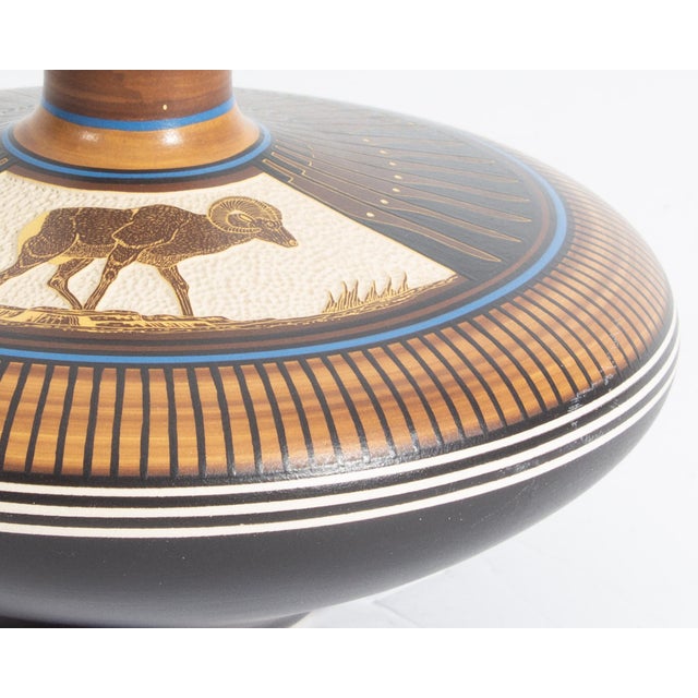 A 1984 vase by Navajo potter William Yazzie. This vase has a narrow neck and wide body with black, brown, and blue hand-...