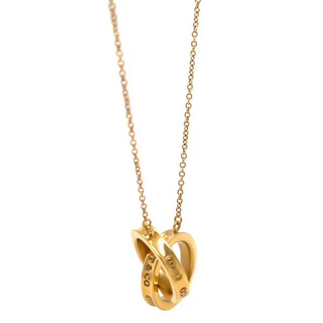 A sleek and modern Tiffany & Co. 1837 interlocking circles pendant necklace crafted in 18ct yellow gold, featuring two...
