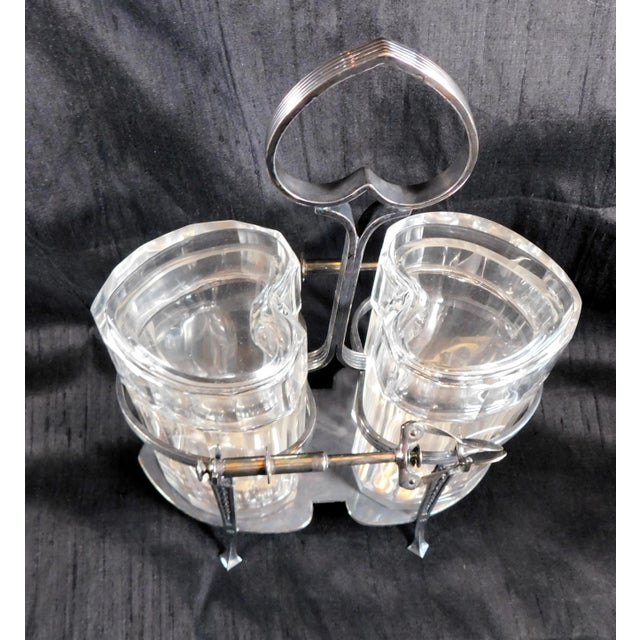 This is a cut crystal heart shaped condiment set of two jars with lids, one stand and two serving tools. A total of seven...