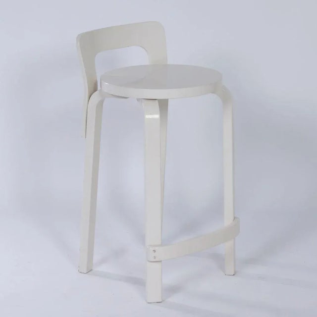 White Alvar Aalto bar stool – high model K65, designed in 1932 – 1933 and produced by Artek (Finland). This stool is from...