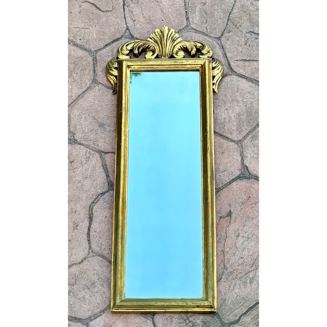 Elegant Spanish giltwood wall mirror dating from circa 1950–1960. The rectangular frame is finished in original gilt with...