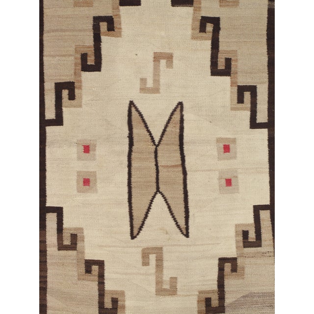 A striking antique Navajo rug dating to circa 1910, handwoven by Navajo artisans in the American Southwest. This beautiful...