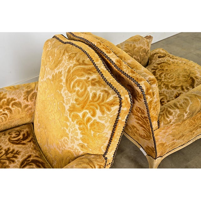 A luxurious and inviting pair of 19th century French Louis XV style carved oak bergeres with olive-gold cut velvet...