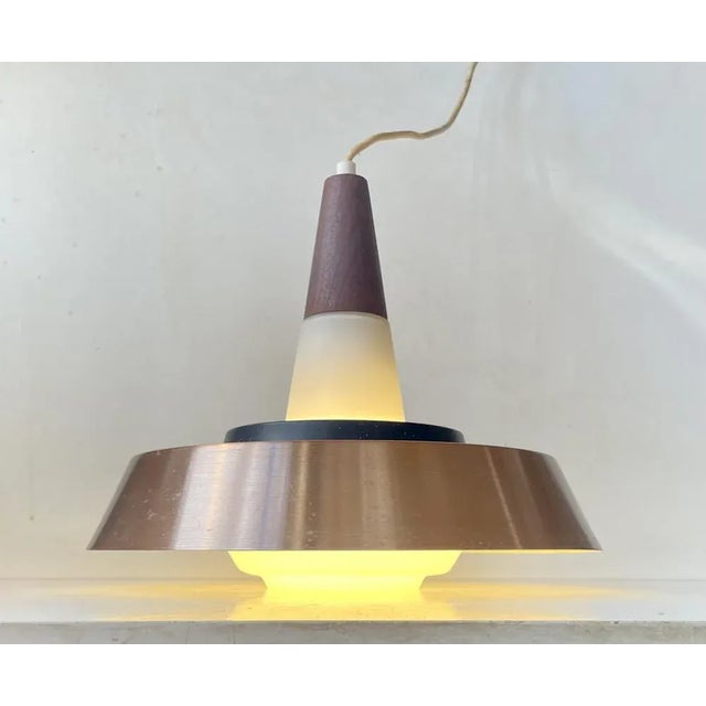 Elegant ballerina shaped ceiling lamp. Its made from hand-blown opaline glass from Holmegaard set with a large copper...
