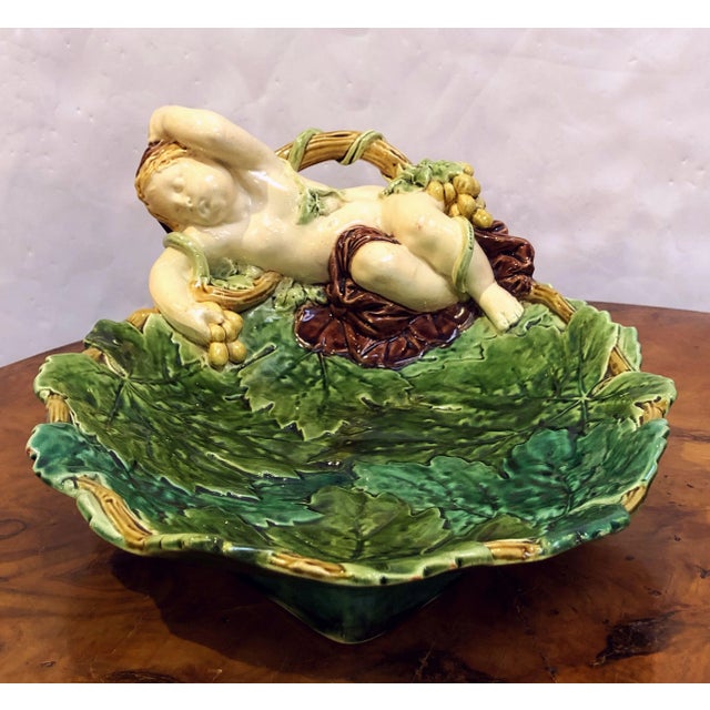 A fine Majolica serving platter or bowl by the celebrated English pottery firm, Minton. Featuring a design of a recumbent...