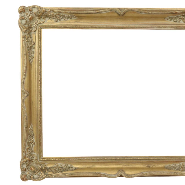 A classic gilded vintage pine frame featuring a characterful aged patina; designed in a full Baroque style and adorned...
