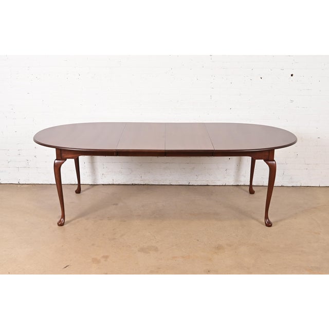 An exceptional Queen Anne or Georgian style solid cherry wood extension dining table By Harden Furniture USA, Circa 1980s...