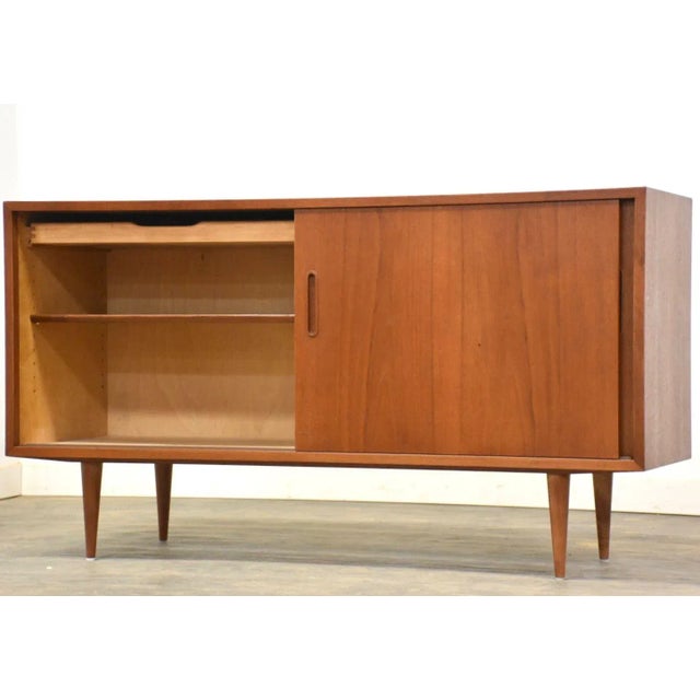 A mid century modern teak credenza with two sliding doors designed by Poul Hundevad. Professionally refinished. 54.5”...